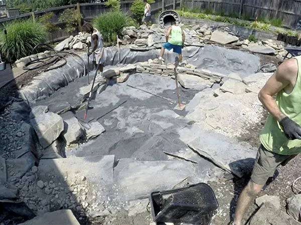 a group of people working on a rock garden.