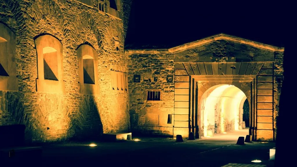 a stone building lit up at night with lights.