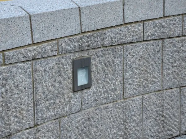 a brick wall with a light switch on it.