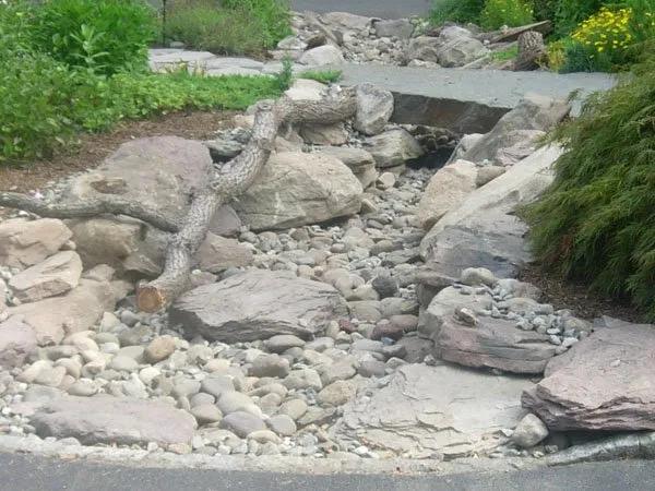 a rock garden with rocks and gravel and a fire hydrant.