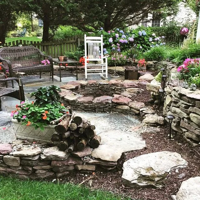 a patio with a fire pit surrounded by rocks.